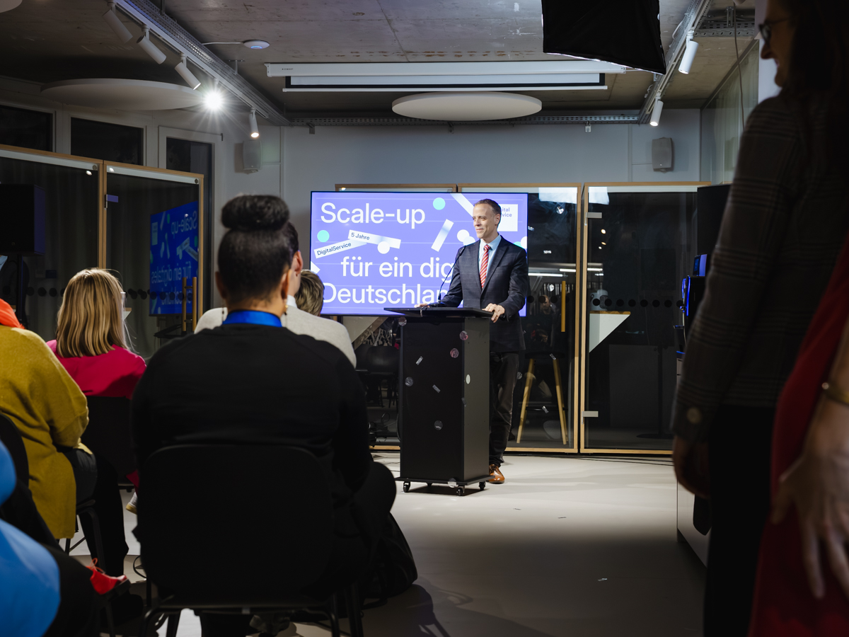 Dr. Markus Richter hält sein Grußwort an einem Rednerpult vor Gäst:innen des Geburtstagsevents