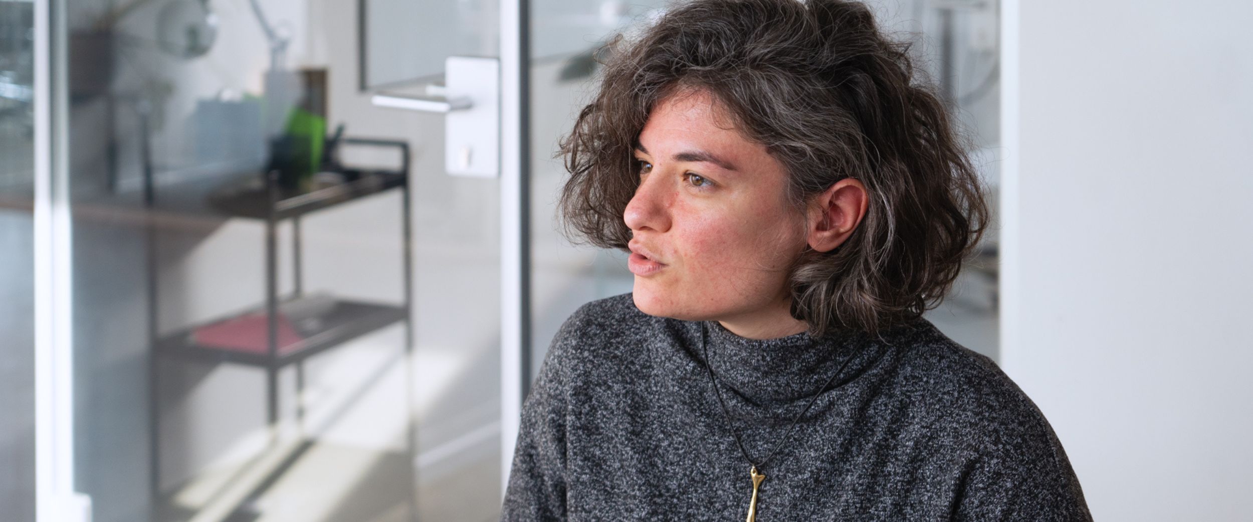 Jana sitzt an einem Tisch und erklärt der interviewenden Person etwas