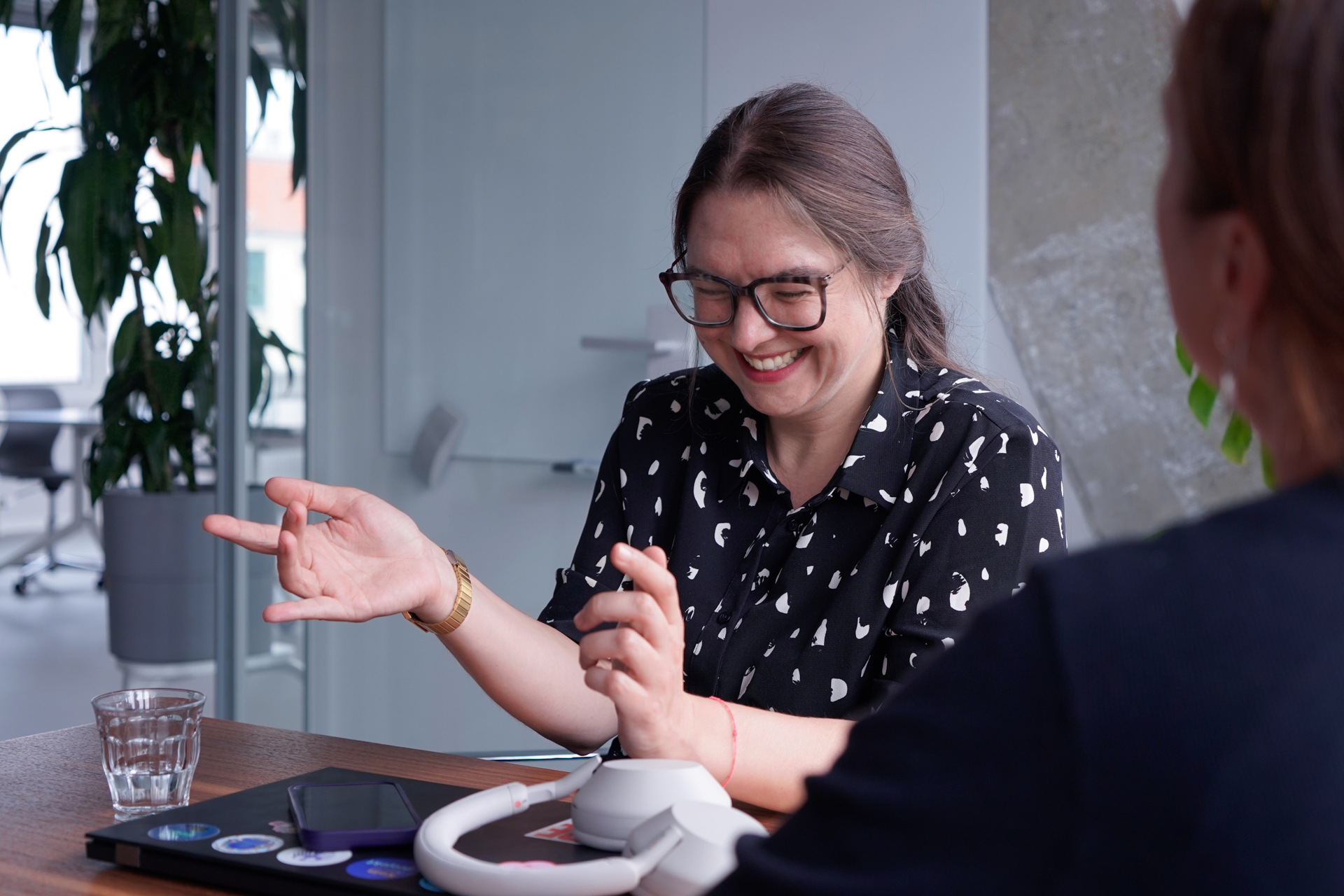 Im Gespräch mit einer Kollegin gestikuliert Lisa mit ihren Händen und lacht herzlich