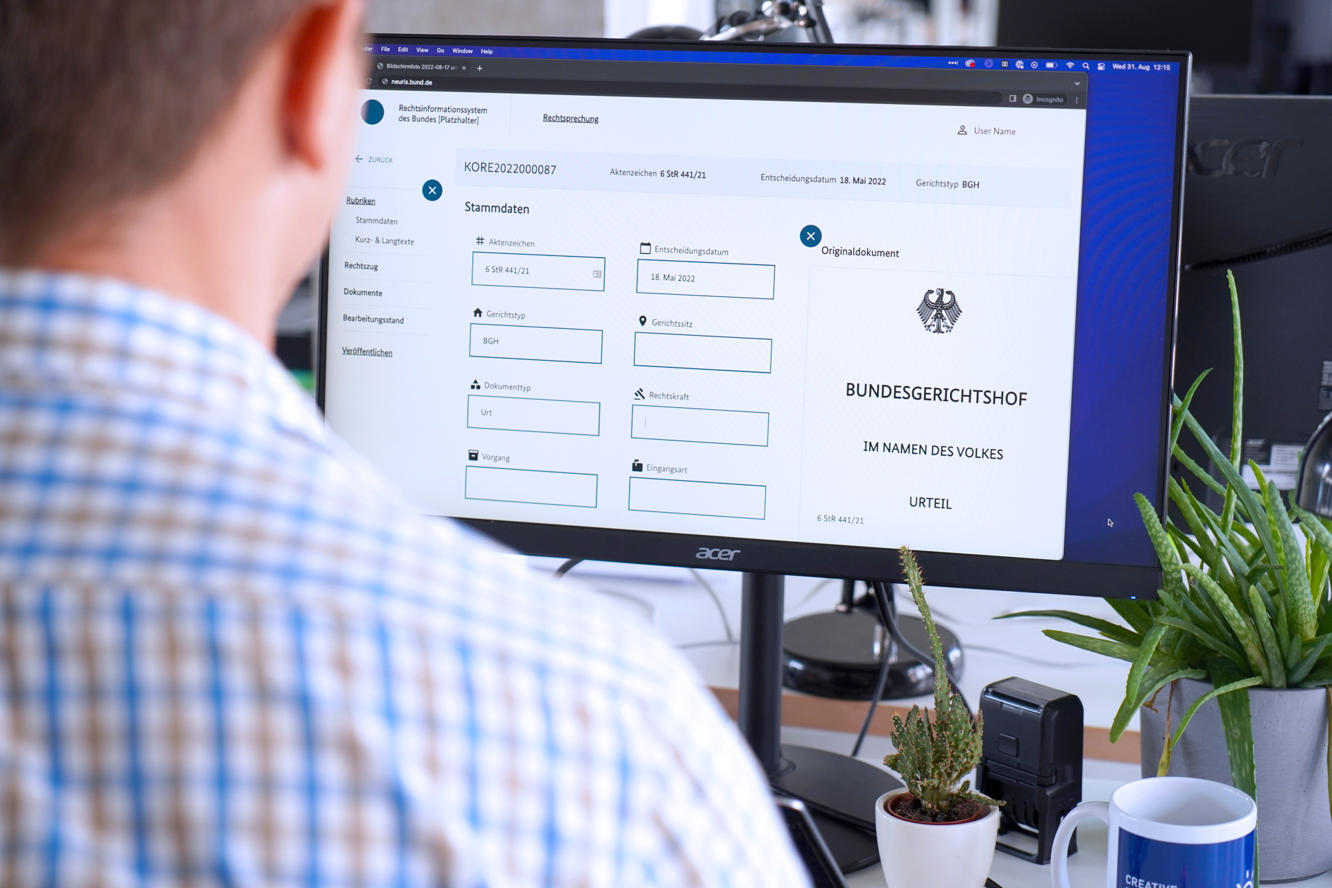 Eine Person sitzt vor einem Rechner. Auf dem Bildschirm ist „Bundesgerichtshof“ und „Stammdatenblatt“ zu lesen.