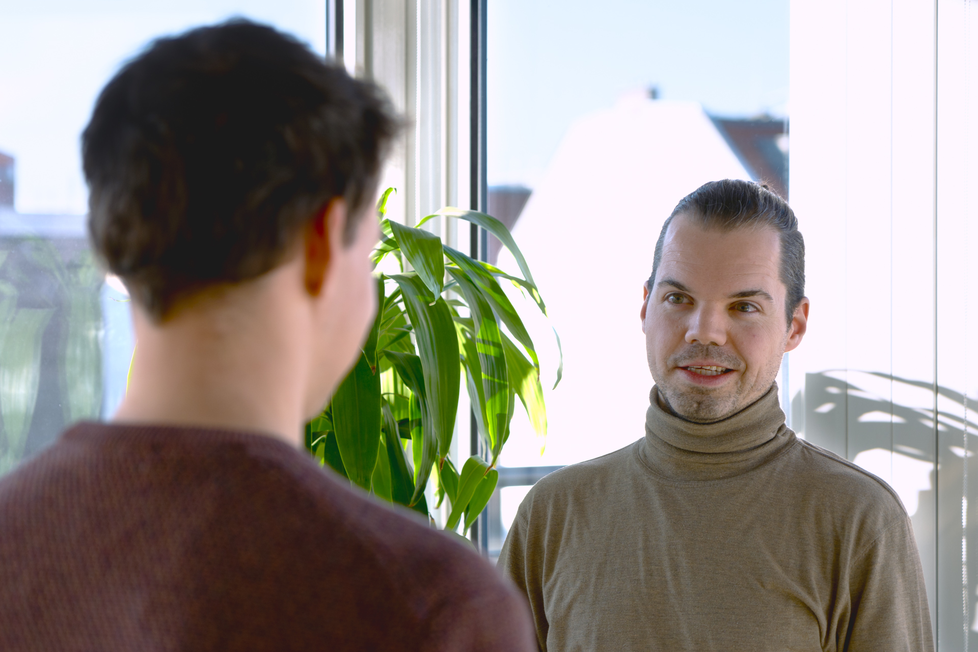 Clemens, einer der Autoren, führt mit einem Kollegen ein Gespräch, der ihm gegenüber steht