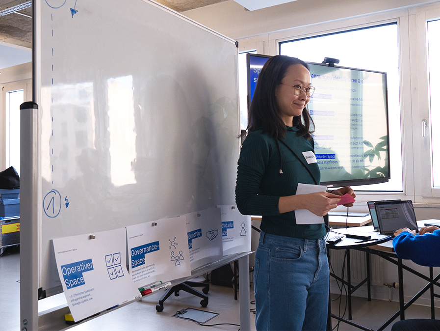 Autorin Kannika steht vor einem Whiteboard, das als Spannungsspeicher dient.