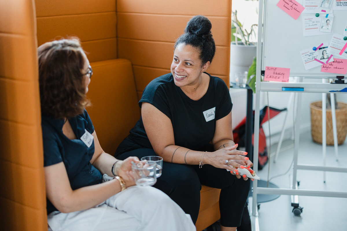 Zwei Menschen unterhalten sich entspannt in einem Workshop-Setting