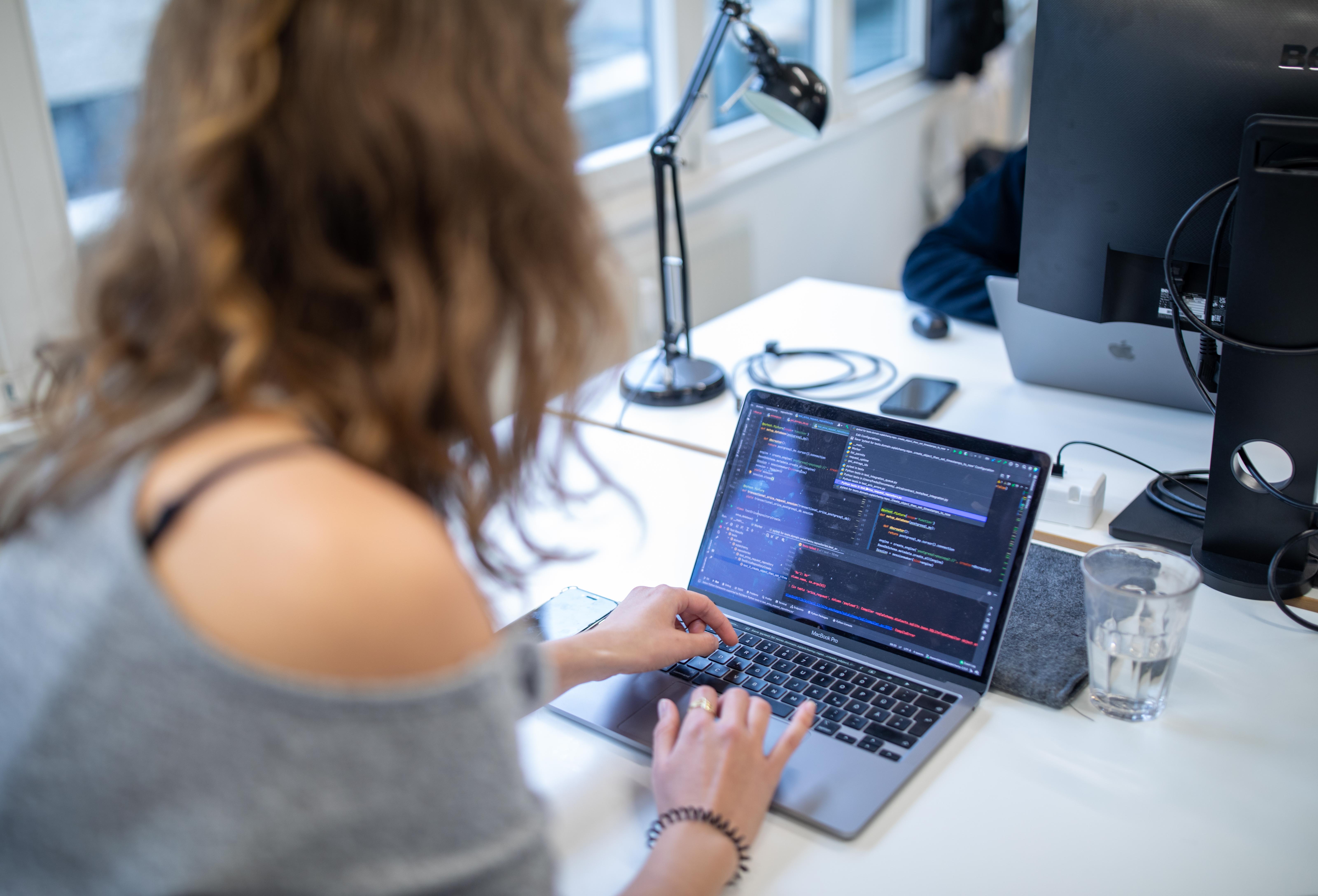 Frederike aus dem Grundsteuer-Team sitzt im Büro an ihrem Laptop und entwickelt „Grundsteuererklärung für Privateigentum