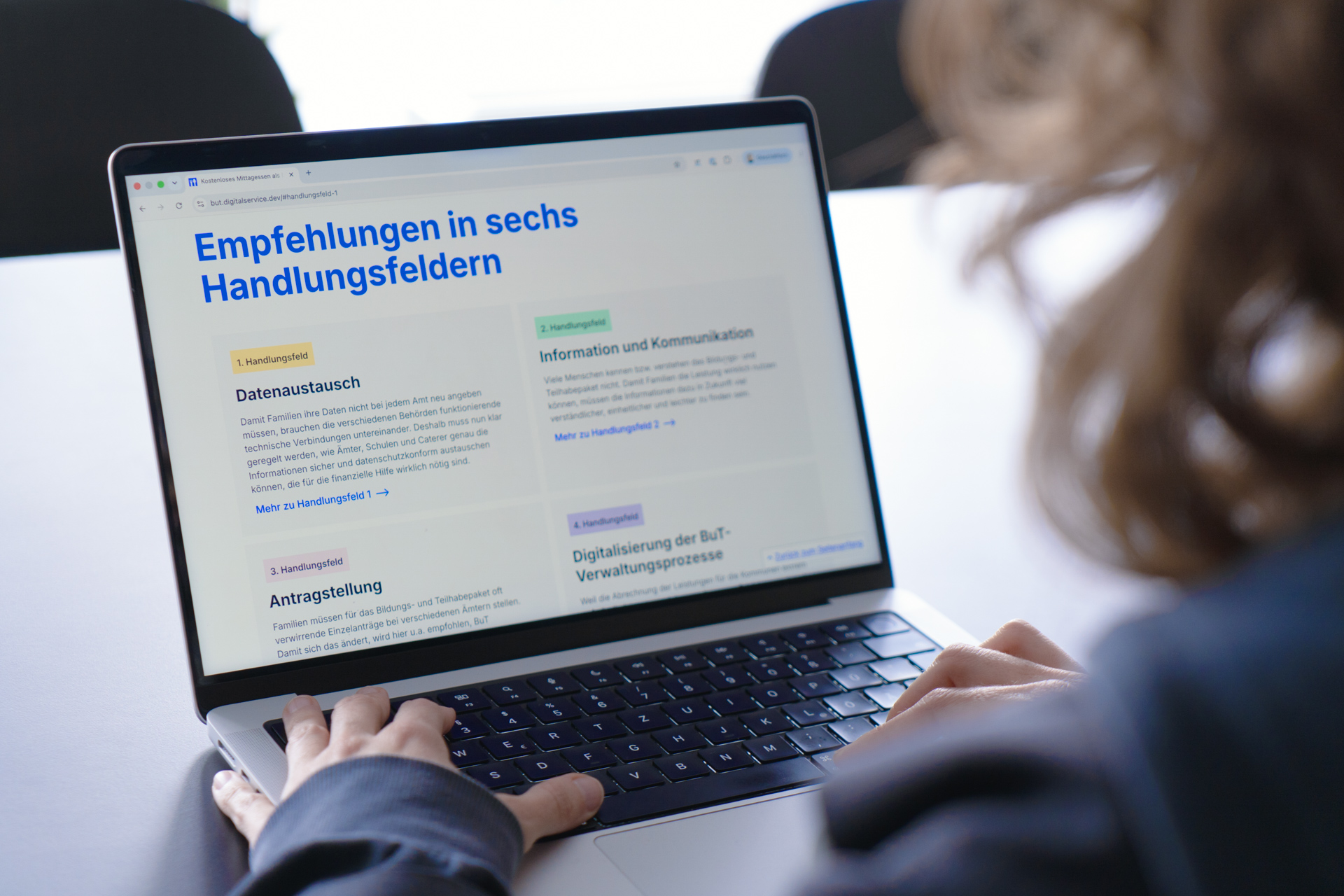Eine Person vor einem Laptop, dessen Bildschirm die Projektwebsite anzeigt. Unter der Überschrift 