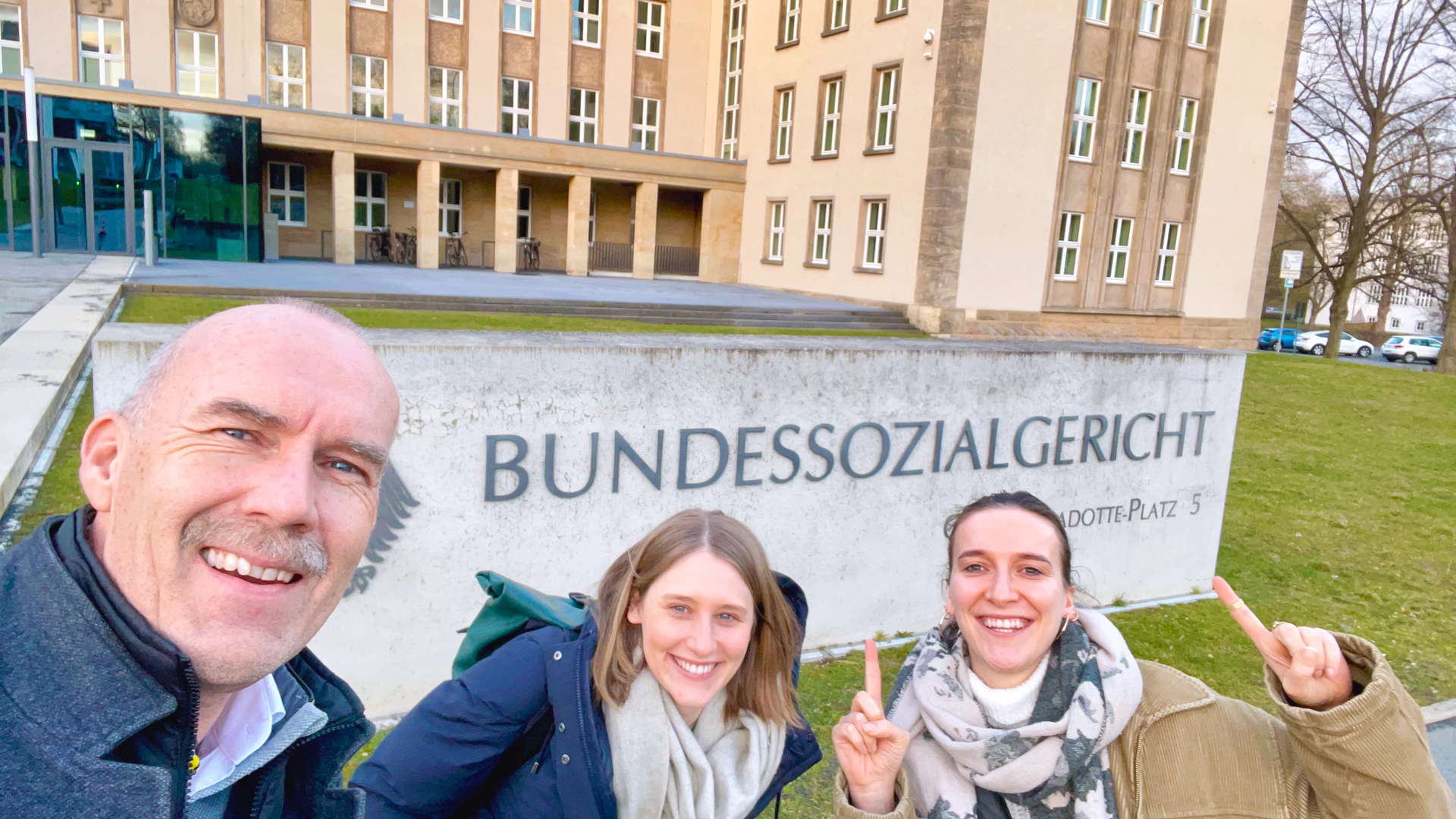 Autor Jörg steht mit zwei Kolleginnen aus seinem Team vor dem „Bundessozialgericht“