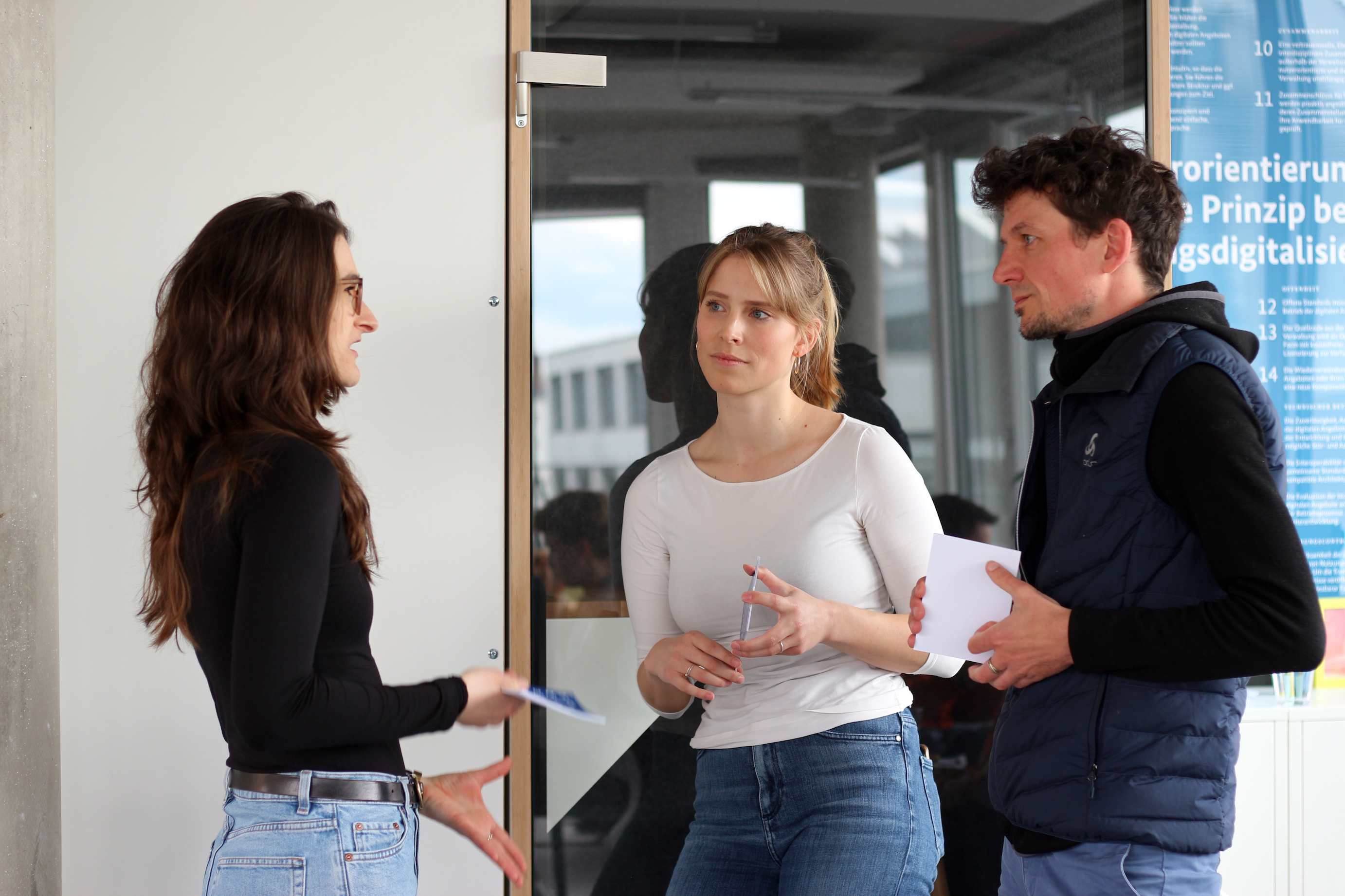 Sonja Anton und Fabian Klenk, die beiden Verantwortlichen der Werte-Arbeitsgruppe des DigitalService, im Gespräch mit einer Kollegin.