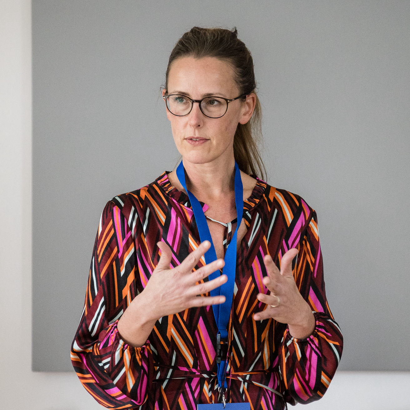 Portraitaufnahme einer ehemaligen Work4Germany Fellow, die gestikuliert und etwas präsentiert.